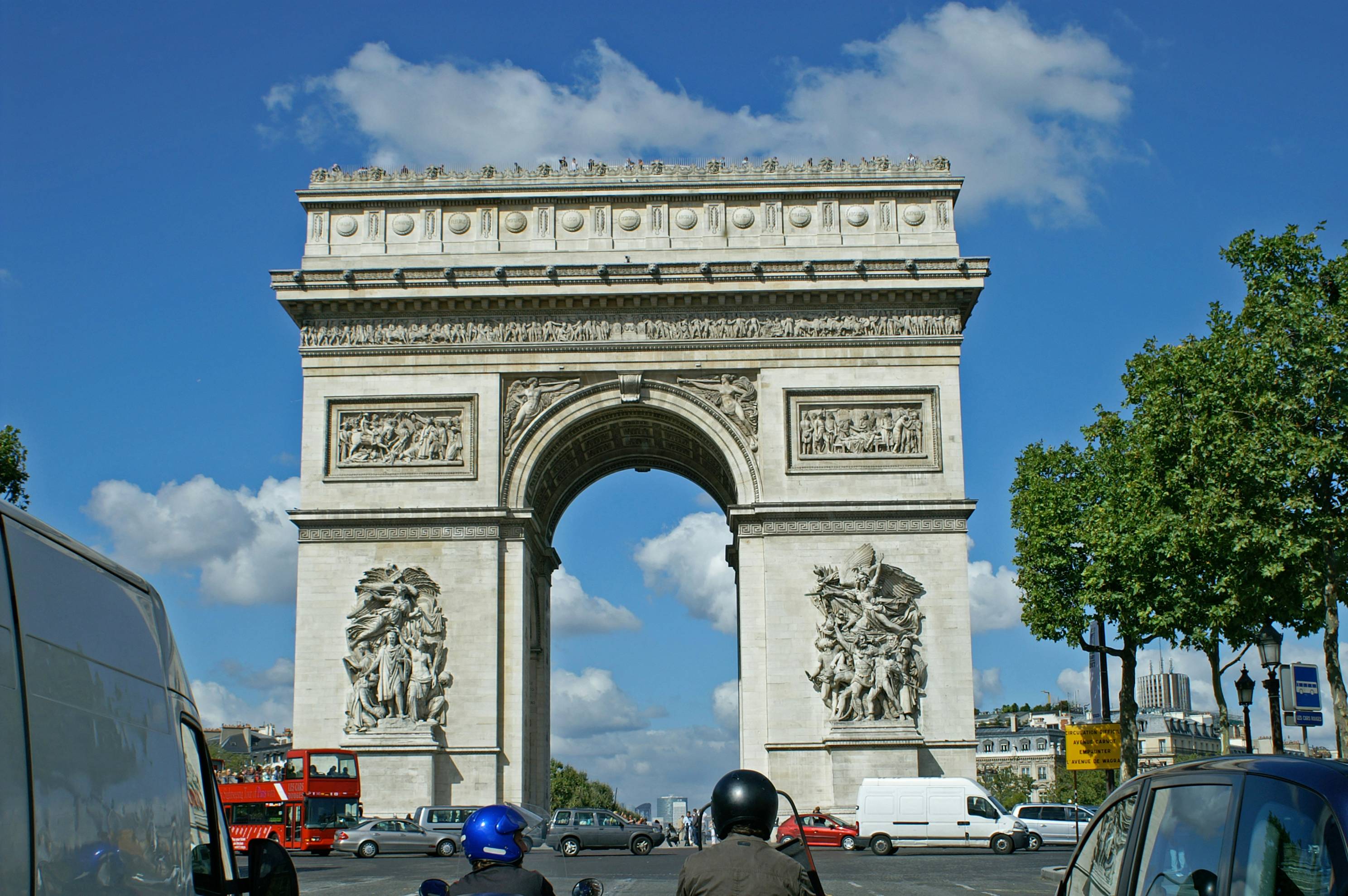 a large stone monument with Arc de Triomphe in the background