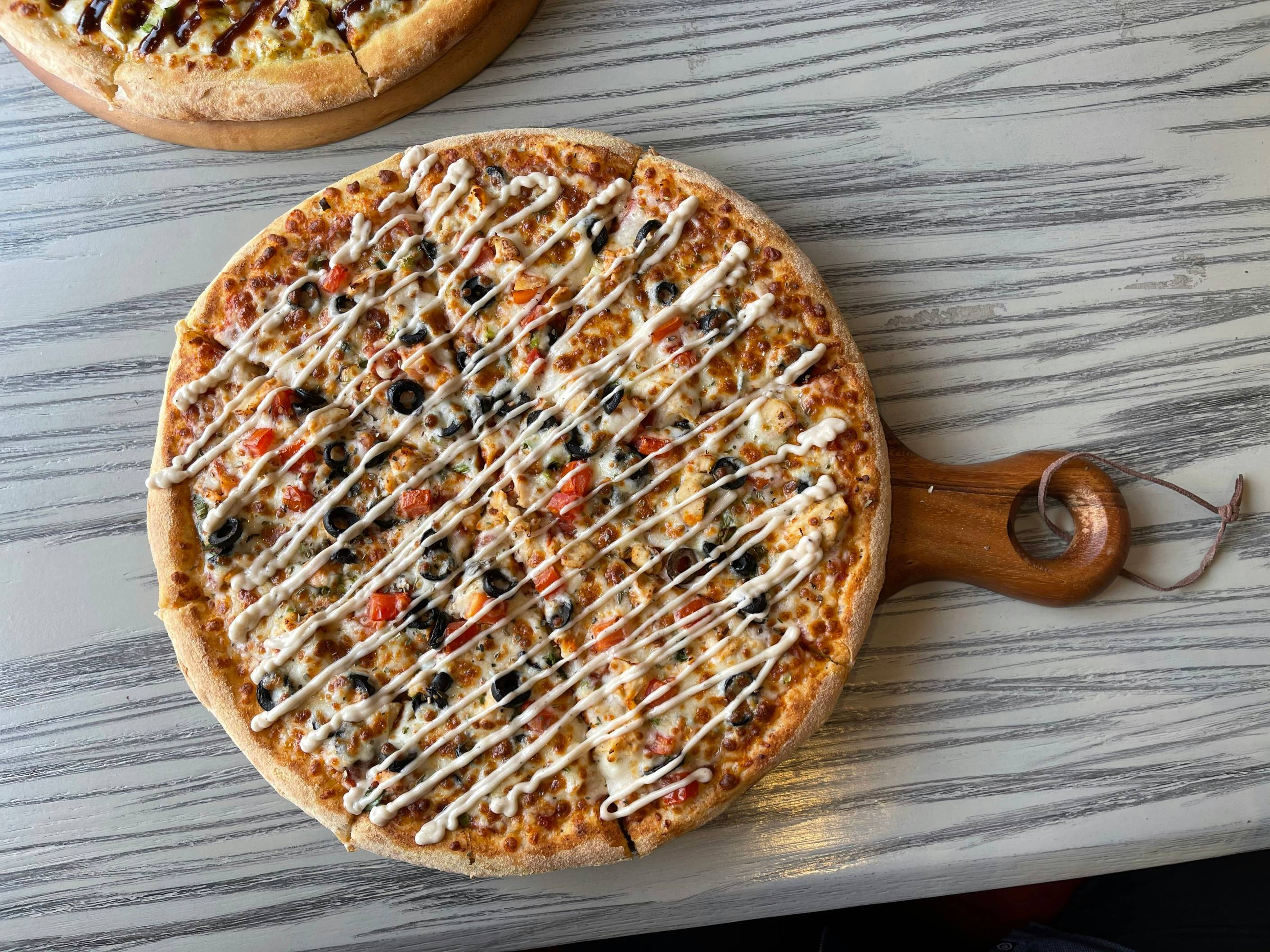 brown round pizza on brown wooden table
